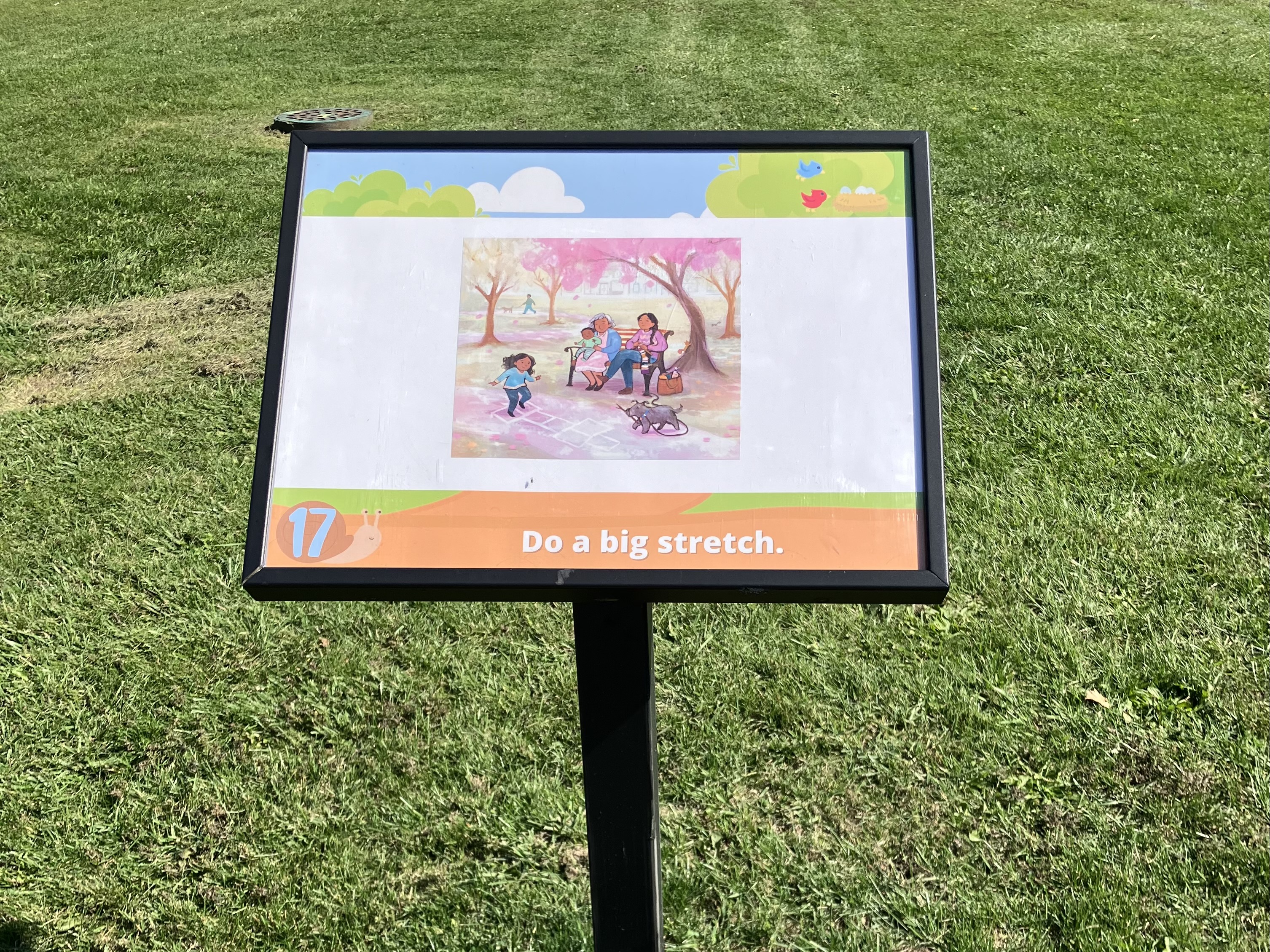Story Trail sign 17 with a single book page. Activity at the bottom: Do a big stretch.